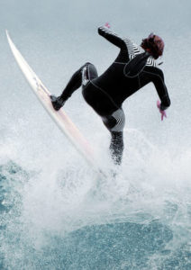 A surfer rides the lip of a wave.