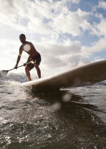 A man paddle boards in the ocean